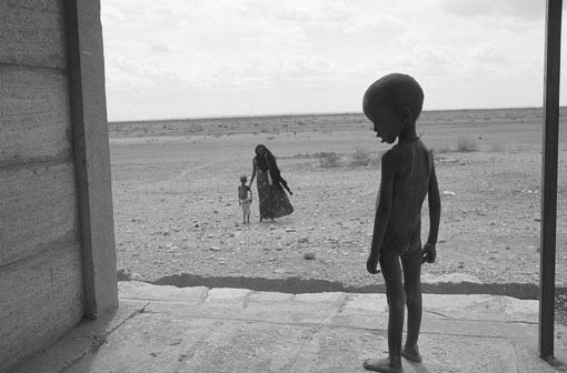 Afrikanisches Kind blickt auf Steppe mit Frau und Kind, © Till Mayer